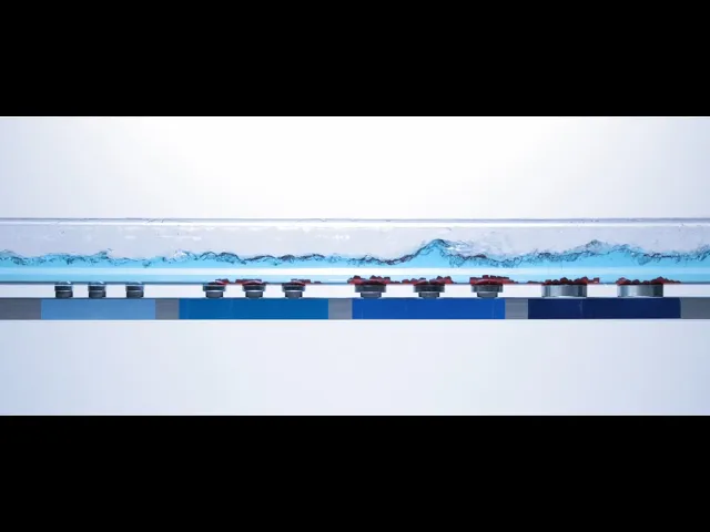 Diagramm einer fließenden Flüssigkeit mit darunter sichtbaren inneren Mechanismen und farbigen Teilen. Veranschaulicht die Rohrleitungs- und Anlagenreinigung mit Comprex®-Technologie für verbesserte Effizienz.